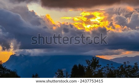 Scenic sunset view of iconic mountain peak Dobratsch seen from Altfinkenstein at Baumgartnerhoehe, Carinthia, Austria. Massive cloud formation. Overlooking Villach area surrounded by Austrian Alps Royalty-Free Stock Photo #2437753415