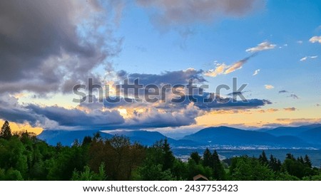 Scenic sunset view of iconic mountain peak Dobratsch seen from Altfinkenstein at Baumgartnerhoehe, Carinthia, Austria. Massive cloud formation. Overlooking Villach area surrounded by Austrian Alps Royalty-Free Stock Photo #2437753423