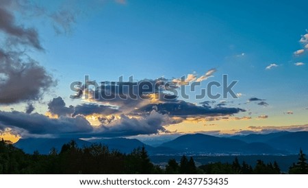 Scenic sunset view of iconic mountain peak Dobratsch seen from Altfinkenstein at Baumgartnerhoehe, Carinthia, Austria. Massive cloud formation. Overlooking Villach area surrounded by Austrian Alps Royalty-Free Stock Photo #2437753435