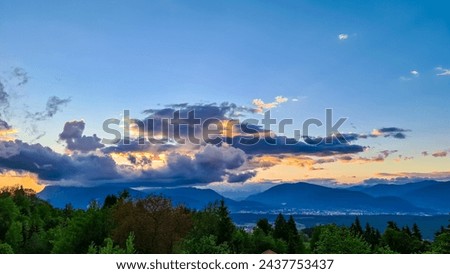 Scenic sunset view of iconic mountain peak Dobratsch seen from Altfinkenstein at Baumgartnerhoehe, Carinthia, Austria. Massive cloud formation. Overlooking Villach area surrounded by Austrian Alps Royalty-Free Stock Photo #2437753437
