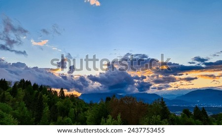 Scenic sunset view of iconic mountain peak Dobratsch seen from Altfinkenstein at Baumgartnerhoehe, Carinthia, Austria. Massive cloud formation. Overlooking Villach area surrounded by Austrian Alps Royalty-Free Stock Photo #2437753455
