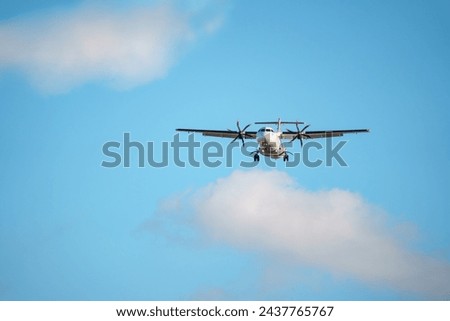 ATR 72 airplane, a twin-engine turboprop short-haul regional passenger aircraft. Landing airplane. Royalty-Free Stock Photo #2437765767