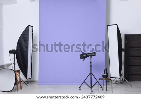 Violet photo background and professional lighting equipment in studio