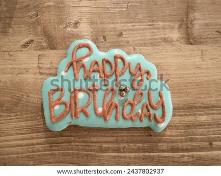 Top view of written happy birthday cookie on a wooden table background