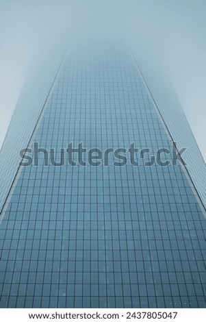 Architectural Elegance of Glass Skyscraper Soaring into Blue Sky