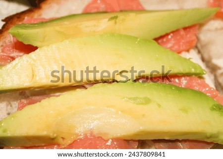 Sandwich with avocado and red fish. Delicious snack high quality stock photo.