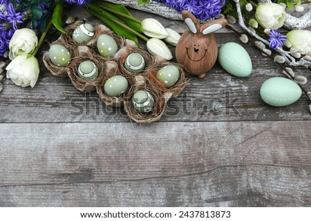 Easter eggs with flowers on a wooden board with space for text.