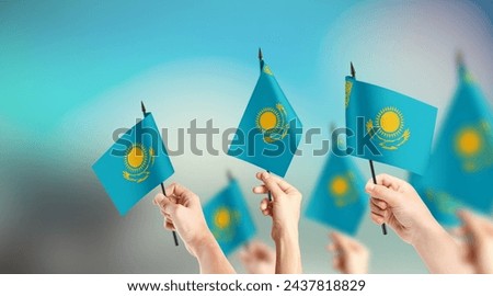 A group of people are holding small flags of Kazakhstan in their hands. Royalty-Free Stock Photo #2437818829