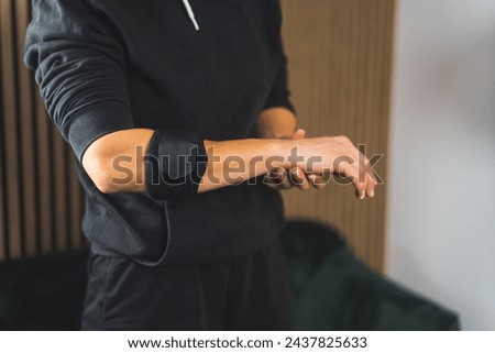 a person in sportswear using an elbow support brace, closeup shot, injuries and healing. High quality photo Royalty-Free Stock Photo #2437825633