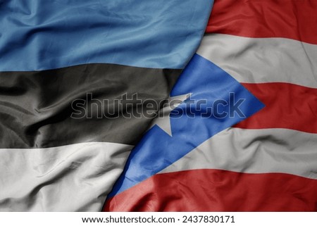big waving national colorful flag of puerto rico and national flag of estonia. macro