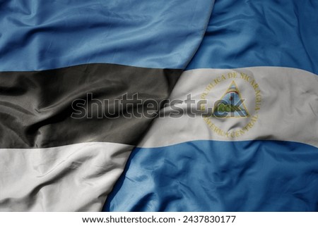 big waving national colorful flag of nicaragua and national flag of estonia. macro