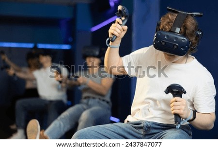 Young man sits in virtual reality headset participates in team e-sports competition. 3D 360 cyber game