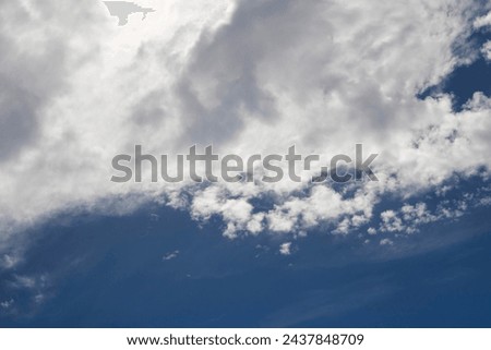 Fluffy white cumulus clouds with some cumulostratus formations on a late summer afternoon are contrasted against the azure blue Australian sky.  Royalty-Free Stock Photo #2437848709