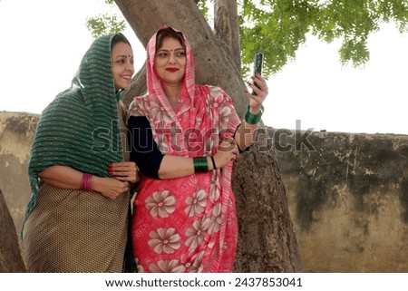Indian happy rural woman taking selfie picture at home in village