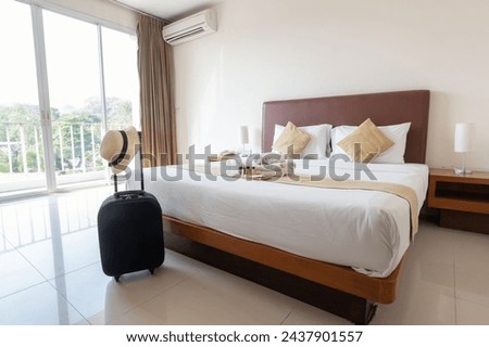 Hotel amenities (such as towels, shampoo, soap, etc) arranged on the bed in hotel bedroom. Hotel amenities is something of a premium nature provided in addition to the room when renting a room. Royalty-Free Stock Photo #2437901557