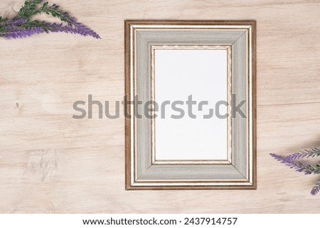 The layout of the frame with a purple bouquet of flowers. A mock-up of an old white portrait frame. The layout of an empty white frame for the design design. View from the top. Royalty-Free Stock Photo #2437914757