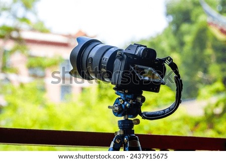 A professional mirrorless camera on a tripod is shooting
