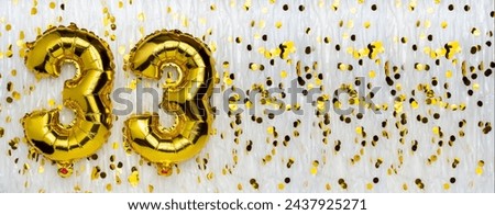 Foil balloon number and digit thirty-three 33. Birthday greeting card. Golden balloons on white background with copy space. Numerical digit. Anniversary concept.