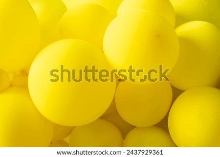 The balloons are all different shades of yellow, from light yellow to dark yellow. A bunch of yellow balloons. The balloons are all different sizes and shapes, and they are all floating in the air. 