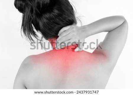 Neck pain muscle stress and strain concept. Stressed blonde woman massaging red sore neck, back view, black and white photo, studio background, copy space