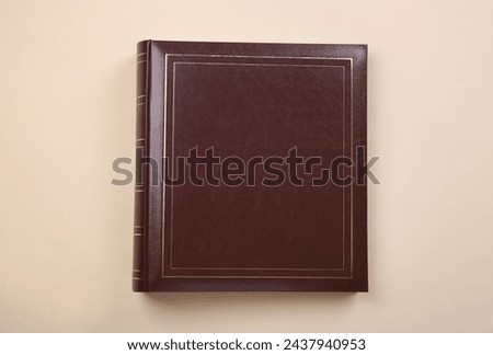 Photo album with leather cover on beige background, top view