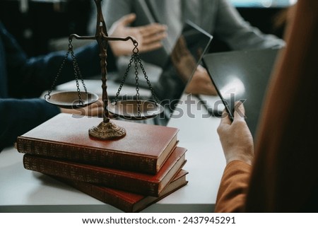 Justice and law concept. Team judge in a courtroom the gavel, working with digital tablet computer on table in sun light.