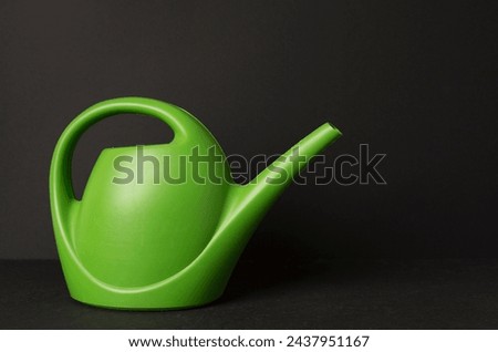 Watering can on concrete background Royalty-Free Stock Photo #2437951167