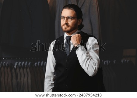 Businessman in classic vest against suit jackets, shop store clothes for men.