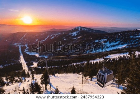 Aerial top view Sheregesh ski lift resort in winter, landscape on mountain with sunset light, Kemerovo region Russia.