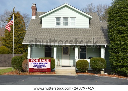 American flag pole real estate for sale open house welcome sign Suburban Bungalow style home with blacktop driveway residential neighborhood USA