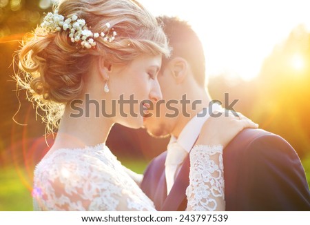Young wedding couple enjoying romantic moments outside on a summer meadow Royalty-Free Stock Photo #243797539