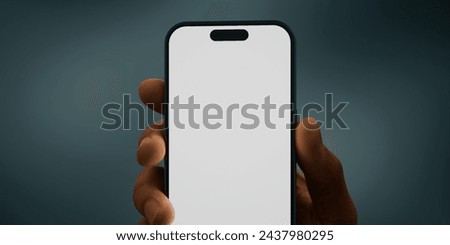 Black African-American hand displays a modern smartphone with a blank screen against a deep teal background, ideal for presenting apps or mobile interfaces in a clean and contemporary setting Royalty-Free Stock Photo #2437980295