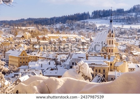 Winter view of Cesky Krumlov, picturesque houses under the castle with snow-covered roofs. Narrow streets and the Vltava river. Travel and Holiday in Europe. Christmas time. UNESCO. Czech Republic