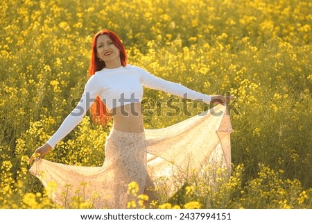 young beauty woman in a field with rapeseed