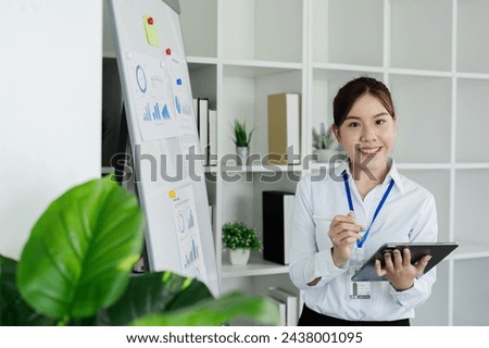 woman standing in front of whiteboard with tablet for present Profit analysis of company while meeting