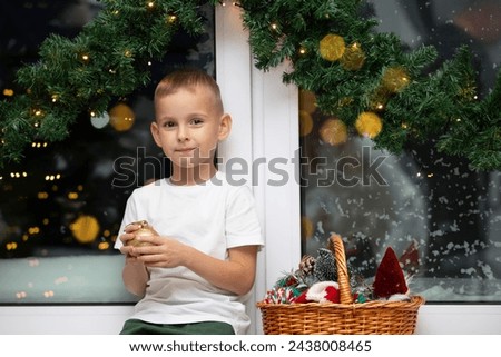 Happy little boy with Christmas tree toys in the Christmas room.