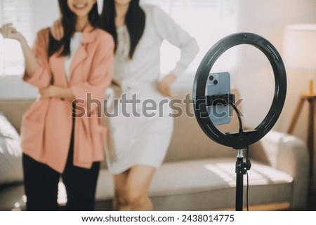 Asian young woman with her friend er created her dancing video by smartphone camera together To share video on social media application Royalty-Free Stock Photo #2438014775