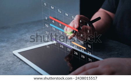 Woman use digital tablet to mark dates on virtual hologram calendar. Businesswoman managing her business schedule. Setting reminders and appointments concept. Planning ideas.