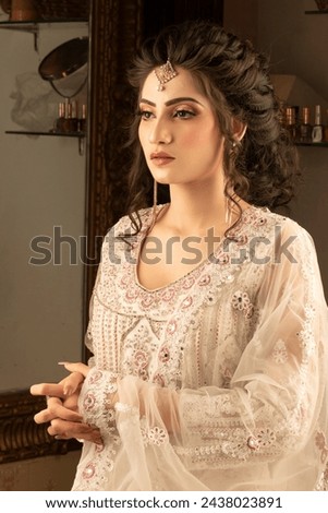 Close up beauty portrait of beautiful young Indian, Pakistani  woman with professional make up. Girl looking aside with long curly hair.