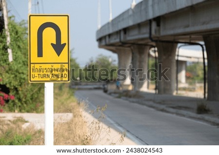 Selective focus of Thailand U-turn ahead sign.Background is public road. 