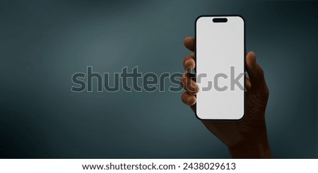 Black African-American hand displays a modern smartphone with a blank screen against a deep teal background, ideal for presenting apps or mobile interfaces in a clean and contemporary setting Royalty-Free Stock Photo #2438029613