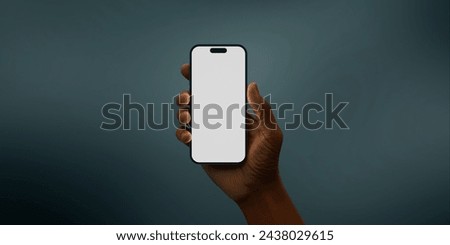 Black African-American hand displays a modern smartphone with a blank screen against a deep teal background, ideal for presenting apps or mobile interfaces in a clean and contemporary setting Royalty-Free Stock Photo #2438029615