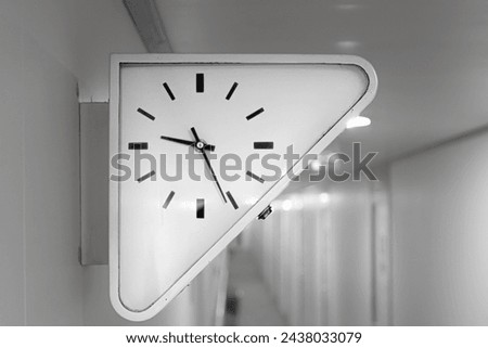 Close-up of white triangle clock at Cruise ship guest hallway or gangway.