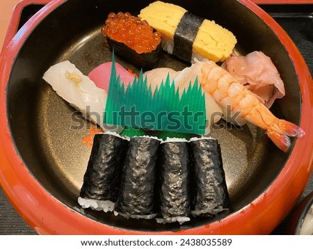 Nigirizushi and makizushi for one person in a sushi tub Royalty-Free Stock Photo #2438035589