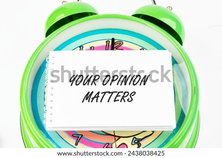 YOUR OPINION MATTERS phrase written on the business card on the alarm clock