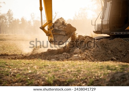 Backhoe working by digging soil at construction site. Bucket teeth of backhoe digging soil. Crawler excavator digging on soil. Excavating machine. Earth moving machine. Excavation vehicle. Royalty-Free Stock Photo #2438041729
