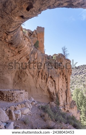 Alcove House at Bandelier National Monument preserves Ancestral Puebloan home in New Mexico. Ceremonial Cave with kiva above Frijoles Canyon. Royalty-Free Stock Photo #2438043453