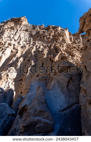 Bandelier National Monument in New Mexico. Hot ash from volcano at Valles Caldera cooled and welded into a rock called tuff. Pajarito Plateau and Frijoles Canyon show Volcanic Geology.  Royalty-Free Stock Photo #2438043457