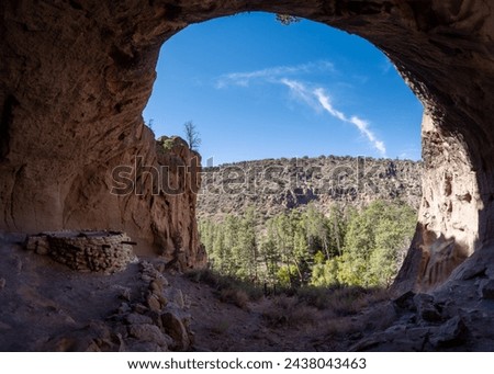 Alcove House at Bandelier National Monument preserves Ancestral Puebloan home in New Mexico. Ceremonial Cave with kiva above Frijoles Canyon. Royalty-Free Stock Photo #2438043463