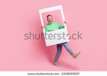 Full body photo of nice retired male walk hold instant photo frame dressed stylish green outfit isolated on pink color background